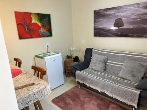 a living room with a couch and a table at Chalé 3 vista para montanha in Itatiaia