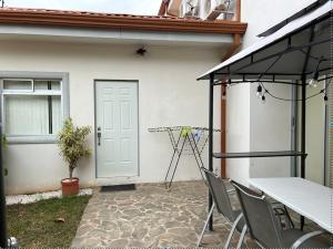 a patio with a table and chairs and a door at casa la luz Orotina in Orotina