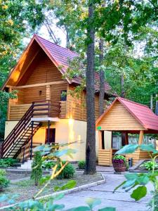 a log cabin with a porch and stairs to it at Вілія in Lomacineţi