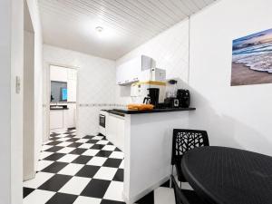 a kitchen with a black and white checkered floor at Flat Jubarte Praia do Francês in Marechal Deodoro