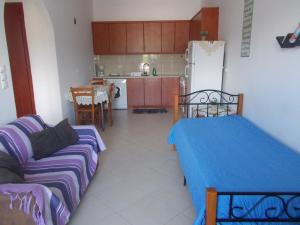 a living room with a couch and a kitchen at Διαμέρισμα τριών ατόμων in Filiatra