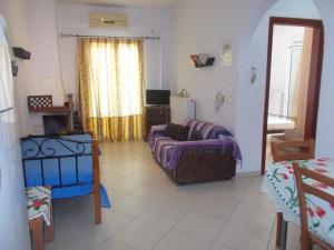 a living room with a couch and a window at Διαμέρισμα τριών ατόμων in Filiatra