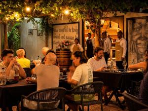 a group of people sitting at tables in a restaurant at Addo African Home in Addo