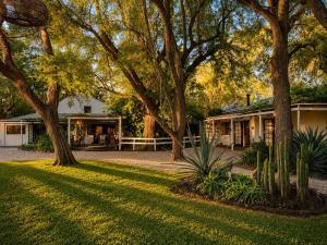 a house with trees in front of a yard at Addo African Home in Addo