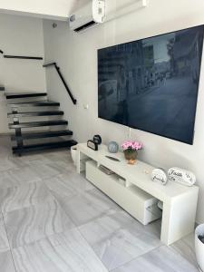 a living room with a large flat screen tv on a wall at Coraçon di Mindel Apartment in Mindelo