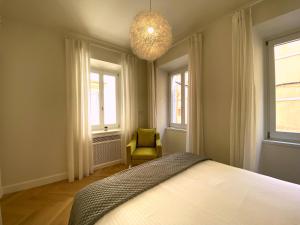 a bedroom with a bed and a chair and windows at Psaradika Apartment Modern Comfort in Corfu Old Town in Corfu