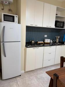 a kitchen with white cabinets and a white refrigerator at Punto San Martin in Venado Tuerto