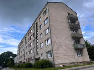 a tall brick building with balconies on the side of it at Light street in Ķekava