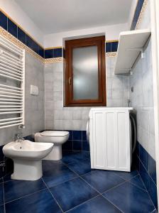 a blue tiled bathroom with a toilet and a sink at Casa con Cortile, Barbecue e Parcheggio Privato in Sestri Levante