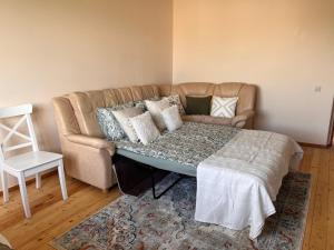 a living room with a couch and a table with pillows at Light street in Ķekava