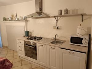 a kitchen with a stove and a sink and a microwave at La Corte della Musica in Roppolo +8 photos