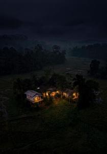 an aerial view of a house in a field at night at Forest & Fields Sinharaja in Deniyaya