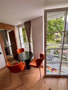 a room with a table and chairs and a balcony at Marių vilos apartamentai Balcony with a Lagoon View in Juodkrantė