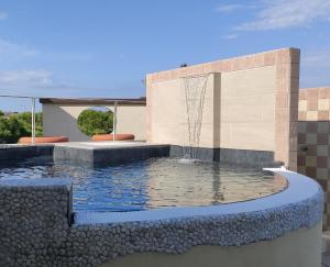 a pool with a fountain in front of a building at Hotel Enrichetta in Desenzano del Garda
