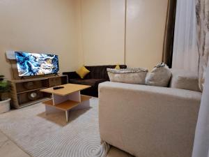 a living room with a couch and a table at Utele Cottages in Thika