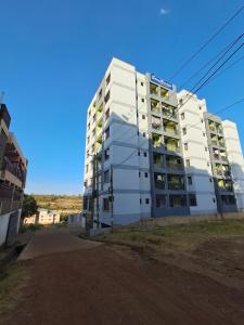 a white apartment building on the side of a road at Utele Cottages in Thika