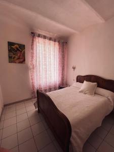 a bedroom with a large bed and a window at Le cadeau bleu, duplex en Cévennes in La GrandʼCombe