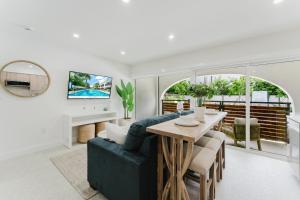 a living room with a table and a couch at Villa Solana - Boca Pool Hideaway in Boca Raton