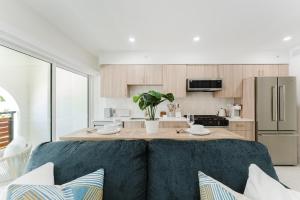 a kitchen with a couch in front of a table at Villa Solana - Boca Pool Hideaway in Boca Raton