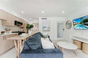 a living room with a blue couch and a table at Villa Solana - Boca Pool Hideaway in Boca Raton