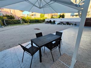 a black table and chairs under an umbrella at Oasi del Sole in Cupra Marittima