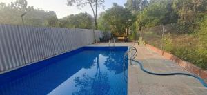 a swimming pool with a hose attached to a fence at Studio Serinity Cove R-2 by Mukund Sadan Arambol in Arambol