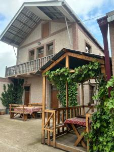 a house with a wooden porch and benches in front of it at Tatev Shinuhayr Hotel' in Shinuhayr