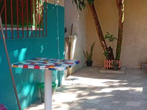 a table in front of a building with a blue wall at Refúgio familiar in Belém