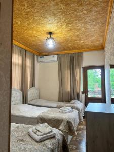 a room with three beds and a table and a window at Tatev Shinuhayr Hotel' in Shinuhayr