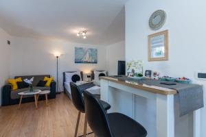 a living room with a kitchen and a living room with a couch at Apartman Hana u blizini ronilačkog kluba i Kostrenskih plaža in Kostrena