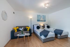 a bedroom with a bed and a couch at Apartman Hana u blizini ronilačkog kluba i Kostrenskih plaža in Kostrena