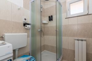 a shower with a glass door in a bathroom at Apartman Hana u blizini ronilačkog kluba i Kostrenskih plaža in Kostrena +25 photos