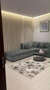 a living room with a couch and a table at شقة انيقة بغرفة وصالة in Buraydah +3 photos