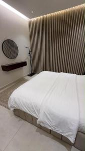 a white bed in a bedroom with a window at شقة انيقة بغرفة وصالة in Buraydah