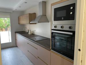 a kitchen with a stove top oven and a microwave at Apartamento Chicuelo in Ariza
