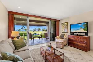 a living room with a couch and a tv at Maui Eldorado Condo J221 in Kaanapali
