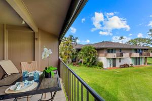 a balcony with a table and a view of a house at Maui Eldorado Condo J221 in Kaanapali