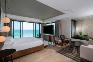 a bedroom with a bed and a room with a television at Hyatt Centric Playa del Carmen - Downtown House & Beach House in Playa del Carmen