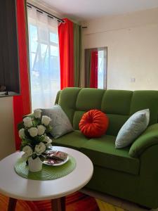 a living room with a green couch and a table at Tulivu House in Embu
