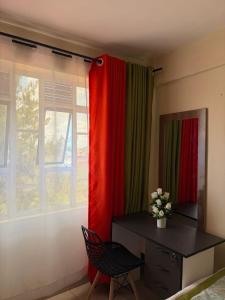 a room with a desk and a red curtain at Tulivu House in Embu +1 photo