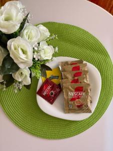 a plate with a snack and a bouquet of white roses at Tulivu House in Embu