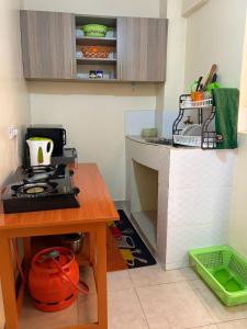 a small kitchen with a stove and a table at Tulivu House in Embu