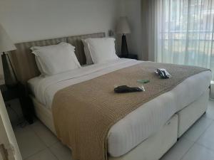 a bedroom with a large white bed with shoes on it at Hôtel de Provence in Cannes