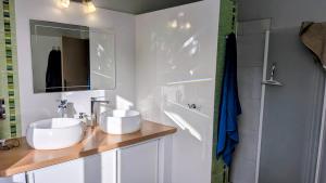 a white bathroom with two sinks and a mirror at Caravane Cosy - 5min Circuit 24h du Mans in Changé