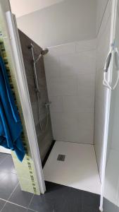 a shower in a bathroom with a glass door at Caravane Cosy - 5min Circuit 24h du Mans in Changé