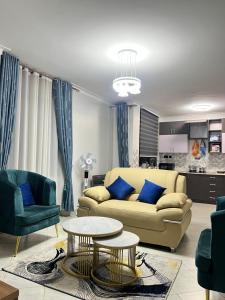 a living room with a couch and two chairs and a table at Supreme Apartments in Kansiri