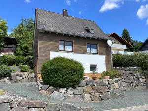a house with a stone wall in front of it at Apartmenthaus RuheZeit in Bad Endbach