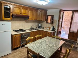 a kitchen with wooden cabinets and a table with a counter top at Casetta IV Vico- Chianalea in Scilla