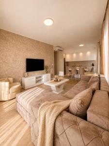 a large living room with a large couch and a tv at Aria Lux Belgrade Waterfront in Belgrade