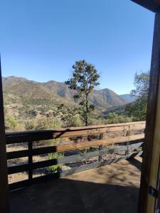 a view of a fence with mountains in the background at Cabaña Ecologica Huinganes in Machalí